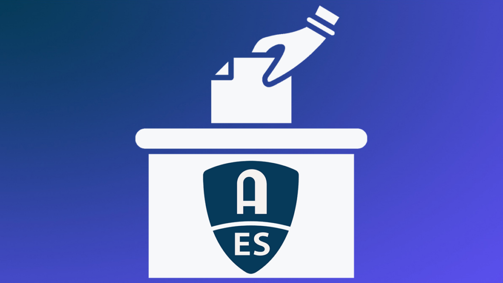 Hand placing ballot in voting box with AES logo on box