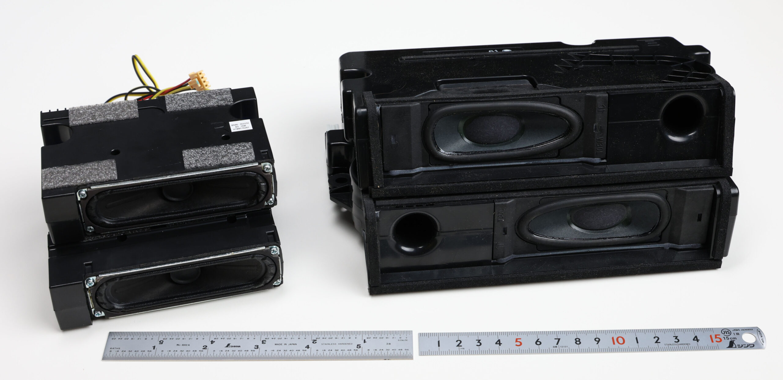 Photo comparing the speaker assemblies from two televisions, showing the larger speakers from the better-performing TV.