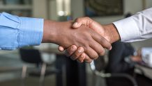 Two people in dress shirts shaking hands